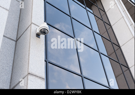 Sorveglianza con controllo remoto telecamera sulla faccia del moderno rivestito in marmo edilizia architettura con cielo riflettente nella finestra Foto Stock