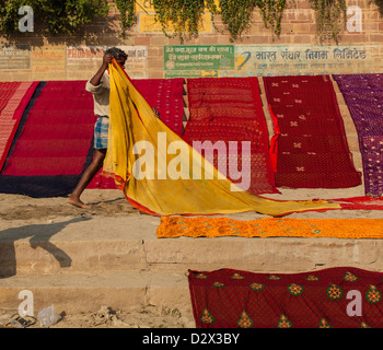 Sari colorati essiccazione su un ghat Varanasi, India Foto Stock