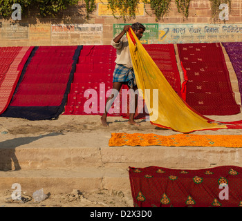 Sari colorati essiccazione su un ghat Varanasi, India Foto Stock