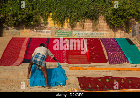 Sari colorati essiccazione su un ghat Varanasi, India Foto Stock