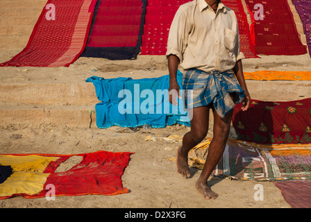 Sari colorati essiccazione su un ghat Varanasi, India Foto Stock