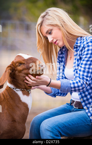 Adolescente femmina petting capra Foto Stock