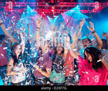 Coriandoli che cadono sopra la folla entusiasta sulla pista da ballo della discoteca Foto Stock