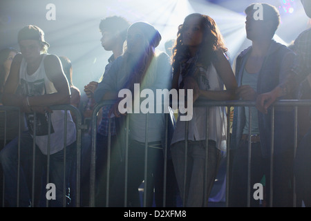 Folla appoggiata sulla ringhiera in concerto Foto Stock