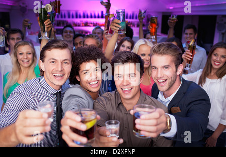 Ritratto di folla entusiasta di bere un cocktail in discoteca Foto Stock