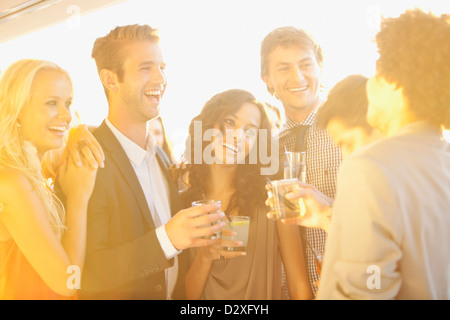 Sorridendo gli amici a bere un cocktail sul balcone soleggiato Foto Stock