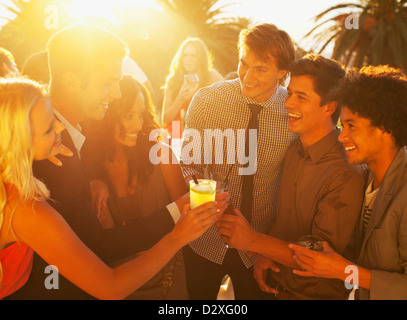 Amici cocktail di tostatura sul balcone soleggiato Foto Stock