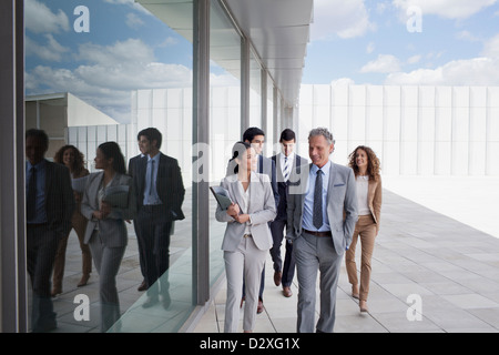 Sorridente la gente di affari a piedi lungo edificio Foto Stock