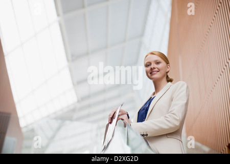 Ritratto di sorridere imprenditrice relazione tenuta in un ufficio moderno Foto Stock