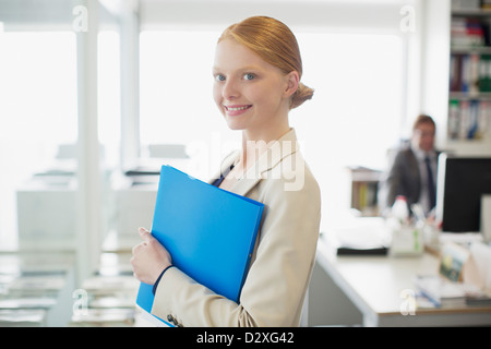 Ritratto di fiducioso imprenditrice apposita cartella Foto Stock