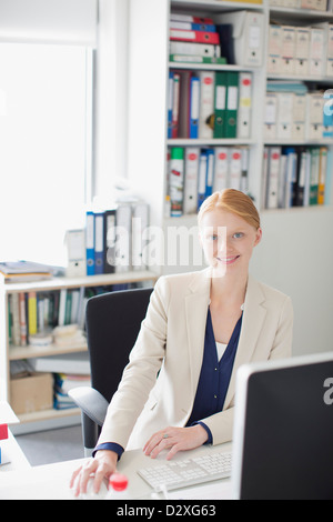 Ritratto di sorridere imprenditrice alla scrivania in ufficio Foto Stock