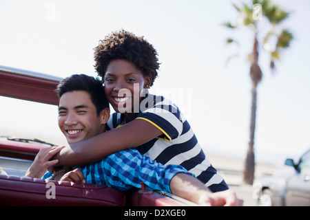 Sorridente giovane costeggiata nel convertibile Foto Stock