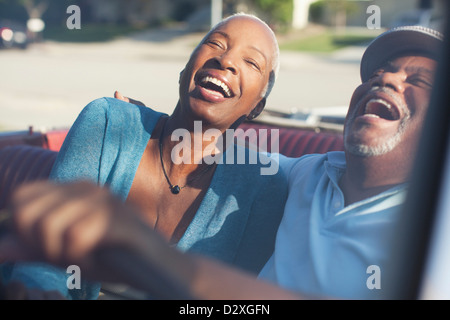 Coppia di anziani ridendo nel convertibile Foto Stock