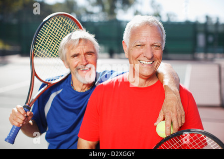 Gli uomini più anziani sorridente sul campo da tennis Foto Stock