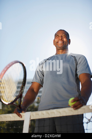 Uomo anziano giocando a tennis su corte Foto Stock