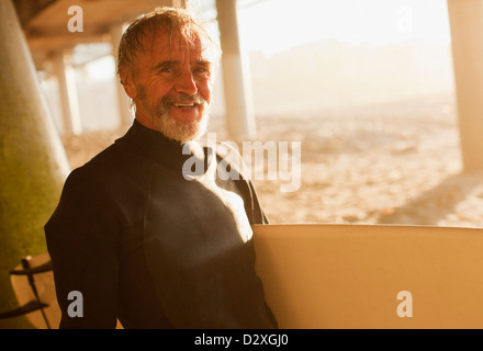 I vecchi surfer scheda portante sulla spiaggia Foto Stock