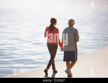 Coppia di anziani camminare insieme sulla spiaggia Foto Stock