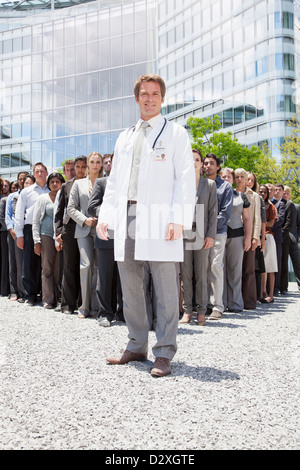 Ritratto di medico sorridente con la gente di affari in background Foto Stock