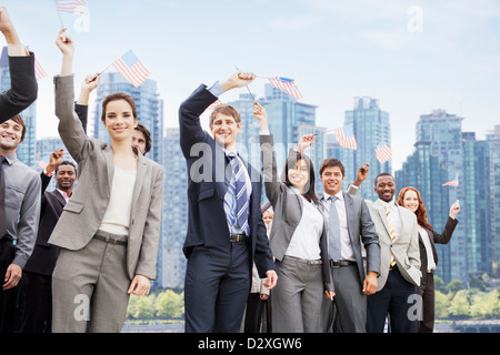 Ritratto di sorridere la gente di affari sventolando bandierine americane Foto Stock