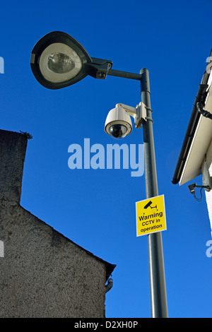 'Avvertimento CCTV in funzionamento'. Avviso e fotocamera su colonna di illuminazione. Foto Stock