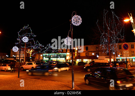 Città illuminata durante le feste di Natale, traffico di notte nella città, Place Clémenceau, Down Town di Mayenne. Foto Stock