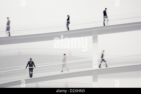 Business sfocata la gente camminare sulle passerelle elevate Foto Stock