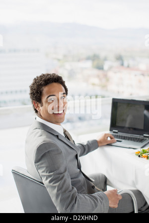 Ritratto di imprenditore sorridente con notebook in ufficio Foto Stock