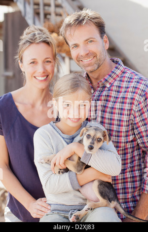 Ritratto di famiglia sorridente holding cucciolo Foto Stock