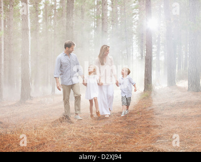 La famiglia felice a piedi nei boschi di sole Foto Stock