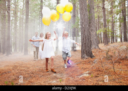 La famiglia felice con palloncini di boschi Foto Stock