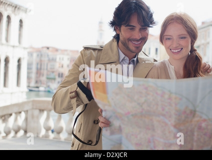 Coppia sorridente che guarda la mappa di Venezia Foto Stock