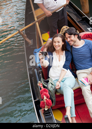 Coppia sorridente scattano fotografie in gondola sul Canal a Venezia