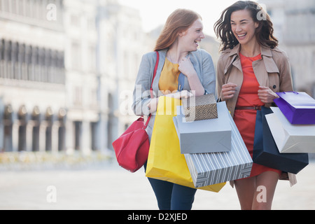 Felici donne con borse per lo shopping a piedi attraverso town square Foto Stock