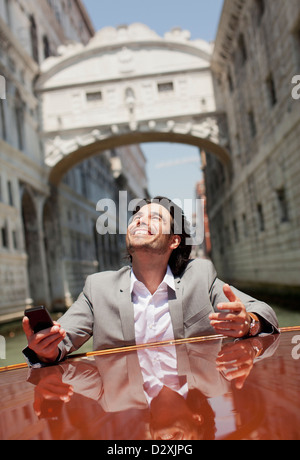 Imprenditore entusiasta equitazione sulla barca attraverso il canale di Venezia Foto Stock