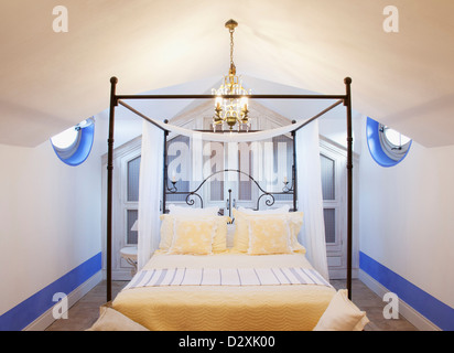 Lampadario sopra il letto a baldacchino in camera da letto di lusso Foto Stock