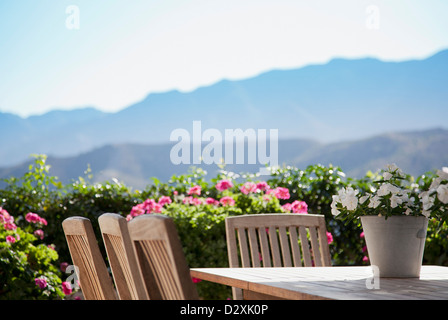 Fiori intorno a un patio tavolo con vista montagna Foto Stock