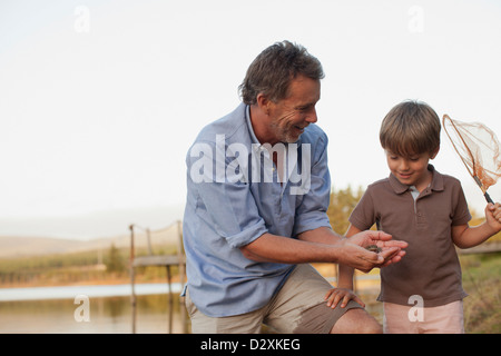 Nonno sorridente e nipote di pesca nel lago Foto Stock
