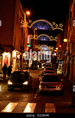 Città illuminata durante le feste di Natale, traffico di notte nel centro della città di Mayenne (Francia). Foto Stock