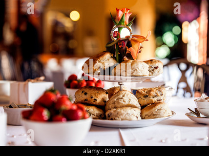 Una tabella composta e stabilite per un inglese un pomeriggio tè alla crema con pane appena sfornato scones, clotted cream e fragole Foto Stock