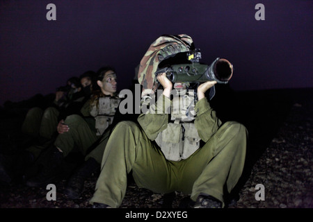 Una soldato israeliana dal Battaglione di intelligenza del campo Eitam del 727th del corpo di raccolta di intelligenza di combattimento usando un Binocolo visione notturna durante l'addestramento avanzato di notte vicino al confine con l'Egitto nel deserto meridionale di Negev Israele Foto Stock