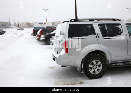 Auto parcheggiate in negozio parcheggio in tempesta di neve blizzard Saskatoon Saskatchewan Canada Foto Stock