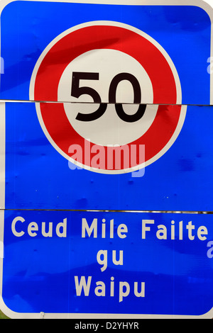 Cartello stradale con limite di velocità e messaggio di benvenuto a Scottish - Ceud Mile Failte gu Waipu (un centinaio di migliaia di accoglie favorevolmente a Waipu) Foto Stock
