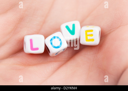 Foto del gioco a cubetti con amore la parola sulla donna di Palm, vacanza romantica, affetto simbolo, romanticismo rapporto, lettere colorate Foto Stock
