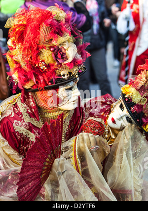 Un paio di indossare maschere tradizionali e costumi di eseguire un amore di scena in Piazza San Marco durante il Carnevale di Venezia giorni. Foto Stock