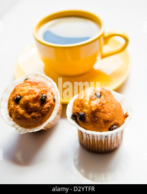 Il caffè in una tazza di colore giallo e muffin Foto Stock