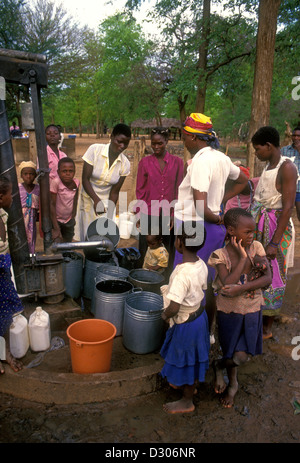 Popolo dello Zimbabwe, delle donne e dei bambini e il pompaggio di acqua dal pozzo, acqua bene, bene acqua, villaggio di Mahenye, Manicaland Province, Zimbabwe, Africa Foto Stock