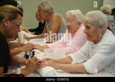 I cittadini anziani godendo di unghie manicure in un centro comunitario Foto Stock