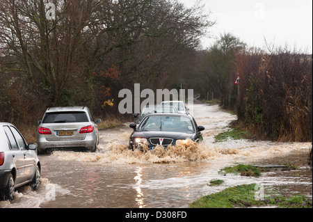 Inondazioni, UK - vetture lotta per guidare lungo un invaso country road, England, Regno Unito Foto Stock