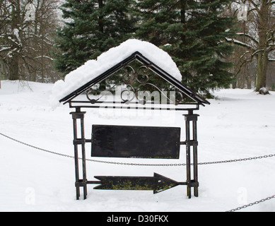 retro steel arrow show direction with blank board place for text covered with winter snow. Foto Stock