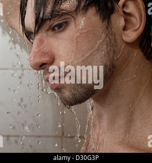 Ritratto di un giovane uomo bello prende una doccia closeup Foto Stock